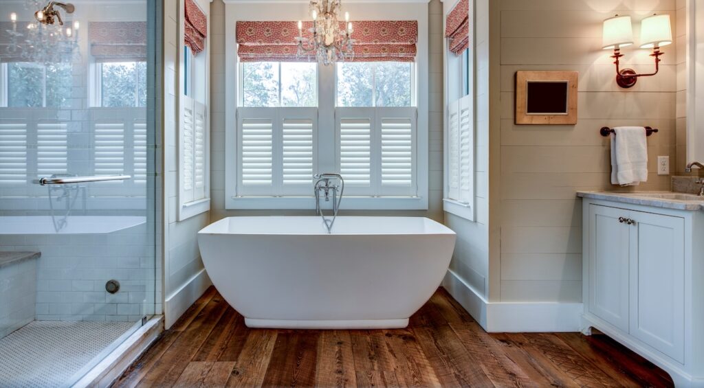 High end bathroom with large white bathtub and shiplap siding.