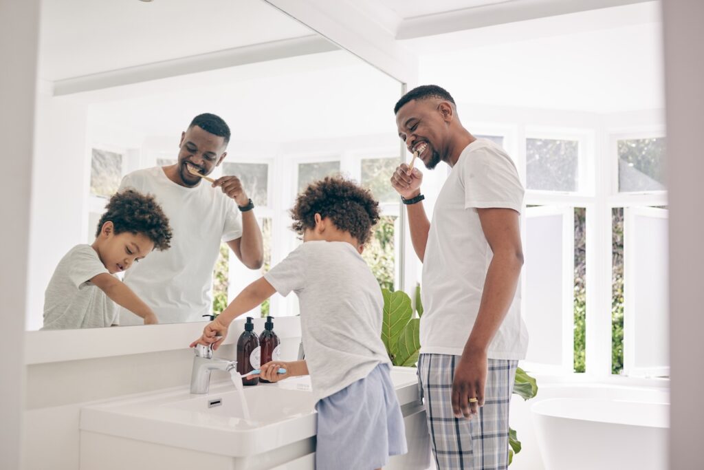 father and son brushing teeth