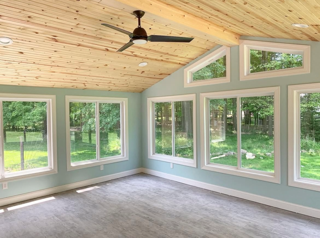 sunroom addition multiple windows wooden roof empty room with a fan